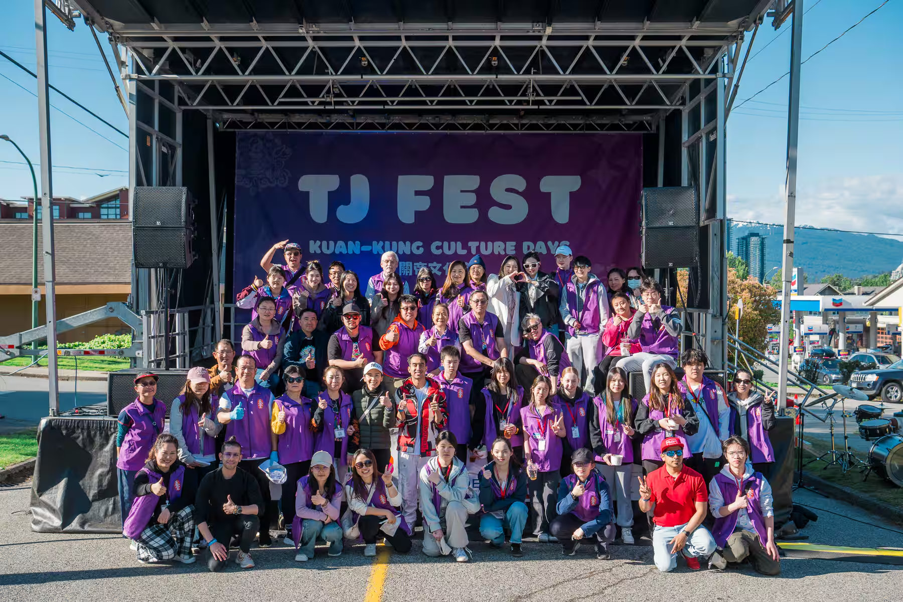 TJ Fest 活動攝影記錄溫哥華本拿比天金堂 TJ Fest 關帝文化節的志工團隊在主舞台上的大合照,展現充滿活力的社區精神與專業的活動攝影。