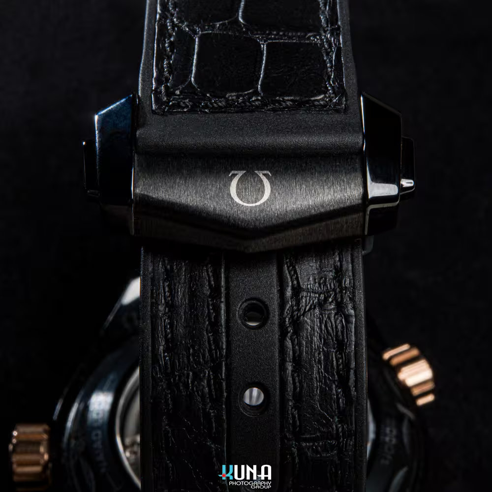 Kuna Photography commercial product photographer macro shot of Omega watch clasp and black alligator leather strap detail.