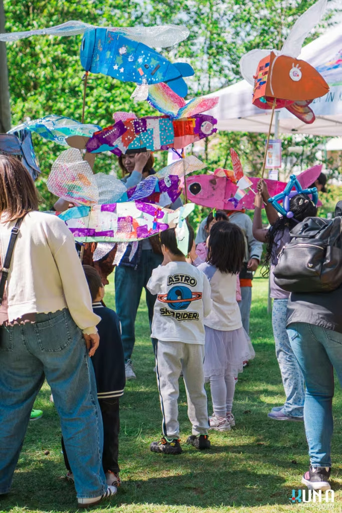 Kuna Photography: Vancouver Event Photographer. Children holding colourful paper fish puppets at a cultural workshop during an outdoor festival in BC.