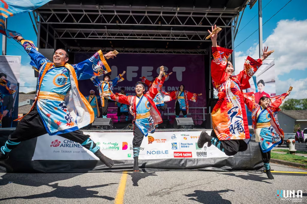 TJ Fest 2025 Kuna Photography: Vancouver Event Photographer. High-energy Yosakoi dancers in red and blue costumes jumping mid-air during a performance in BC.