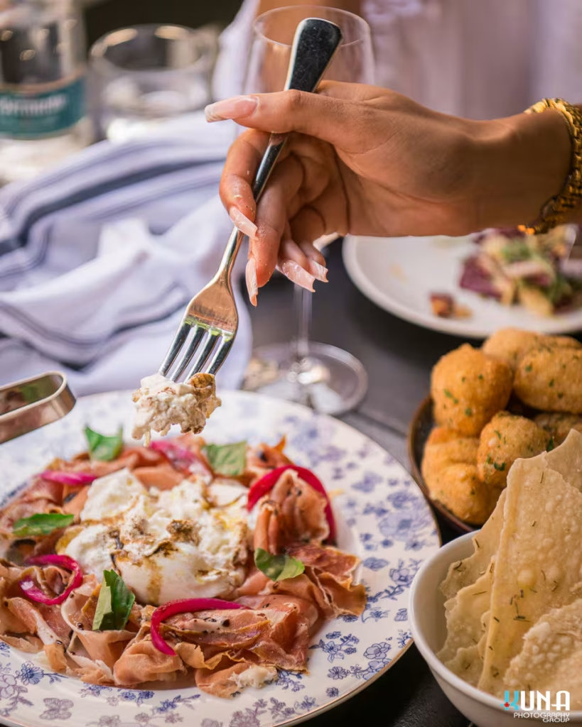 Close-up of creamy burrata and prosciutto plate at Capo and The Spritz, Vancouver.