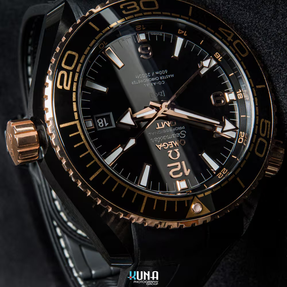 Kuna Photography - Omega Seamaster Crown & Bezel Detail Kuna Photography commercial product photographer close-up of Omega Seamaster Planet Ocean Deep Black ceramic watch dial and Sedna gold crown.