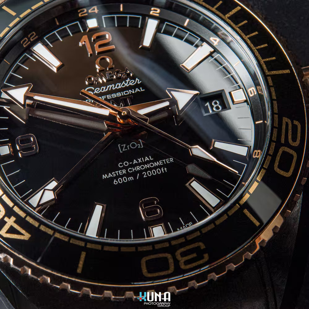 Kuna Photography - Omega Master Chronometer Dial Inscription Kuna Photography commercial product photographer extreme macro of Omega Master Chronometer movement text and gold indices on black dial.