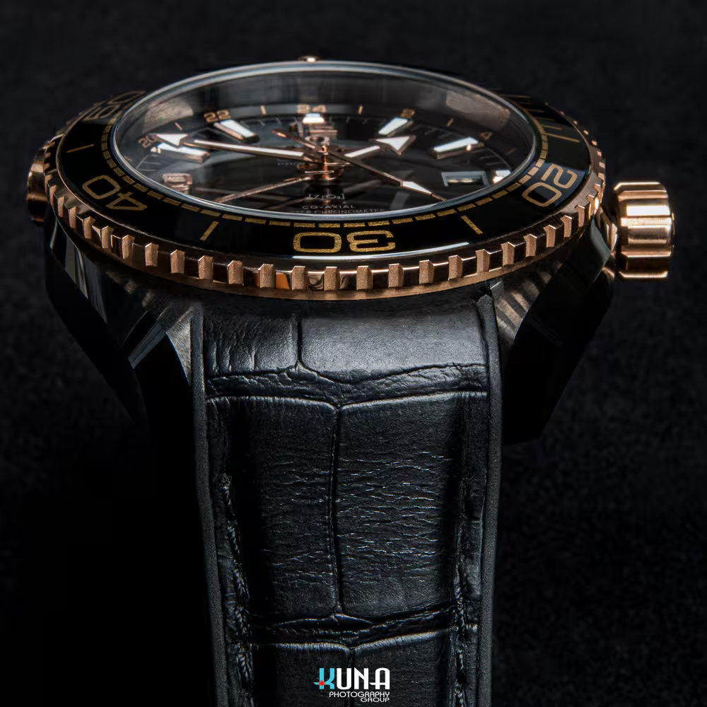 Kuna Photography - Omega Sedna Gold Bezel Texture Detail Kuna Photography commercial product photographer low angle side view of knurled Sedna gold bezel and ceramic case of Omega Seamaster.