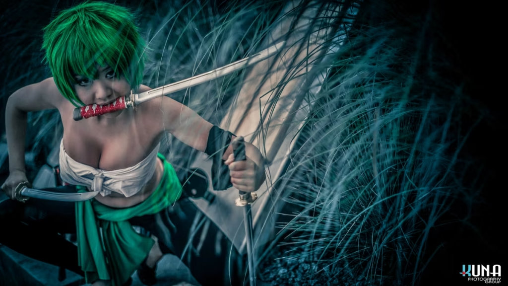 Close-up profile of female Zoro cosplayer holding three swords in tall grass, professional Vancouver Cosplay Photographer