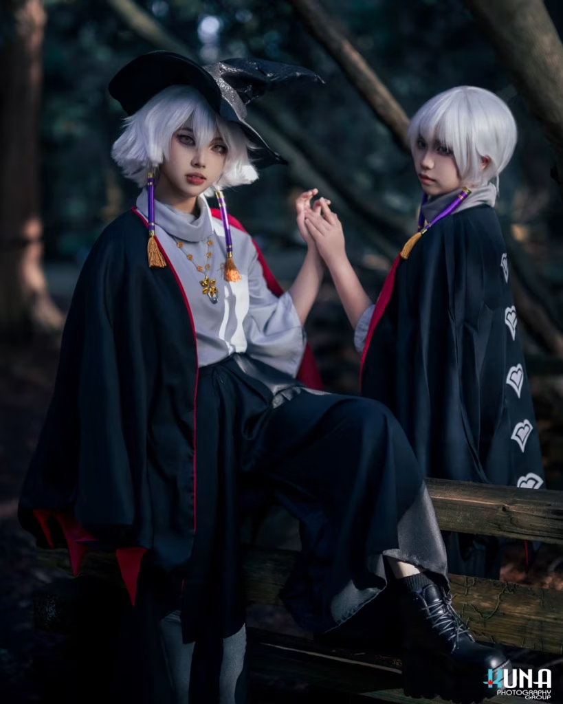 Children of the Light cosplay duo sitting on a wooden fence in a dark forest holding hands, photographed by a Vancouver cosplay photographer.