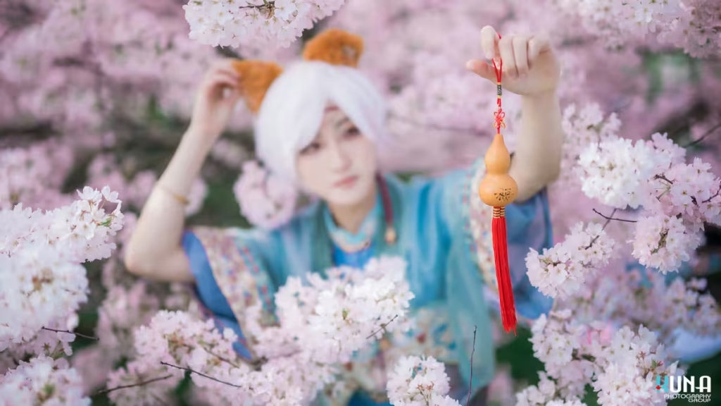 Cosplayer holding a traditional Chinese gourd charm in a field of cherry blossoms, Vancouver.