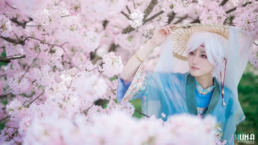 Cosplayer wearing a traditional straw hat with a white veil in a Vancouver cherry blossom park.
