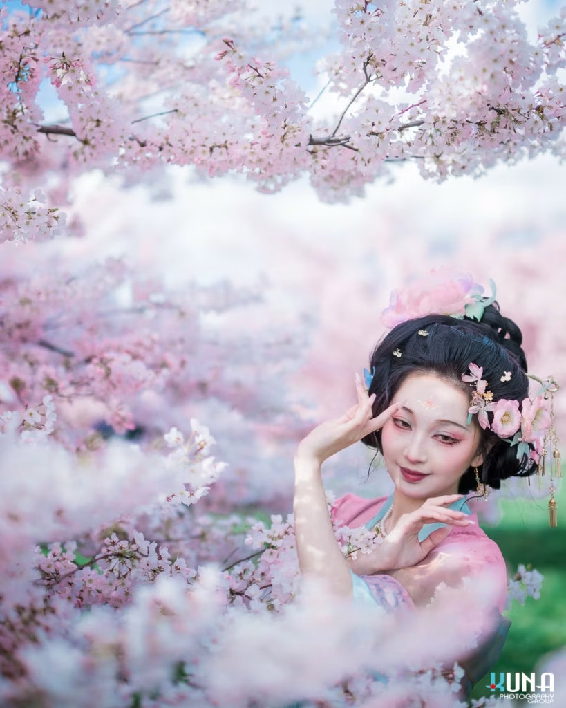 Close-up of a girl in Hanfu posing gracefully among Vancouver cherry blossoms.