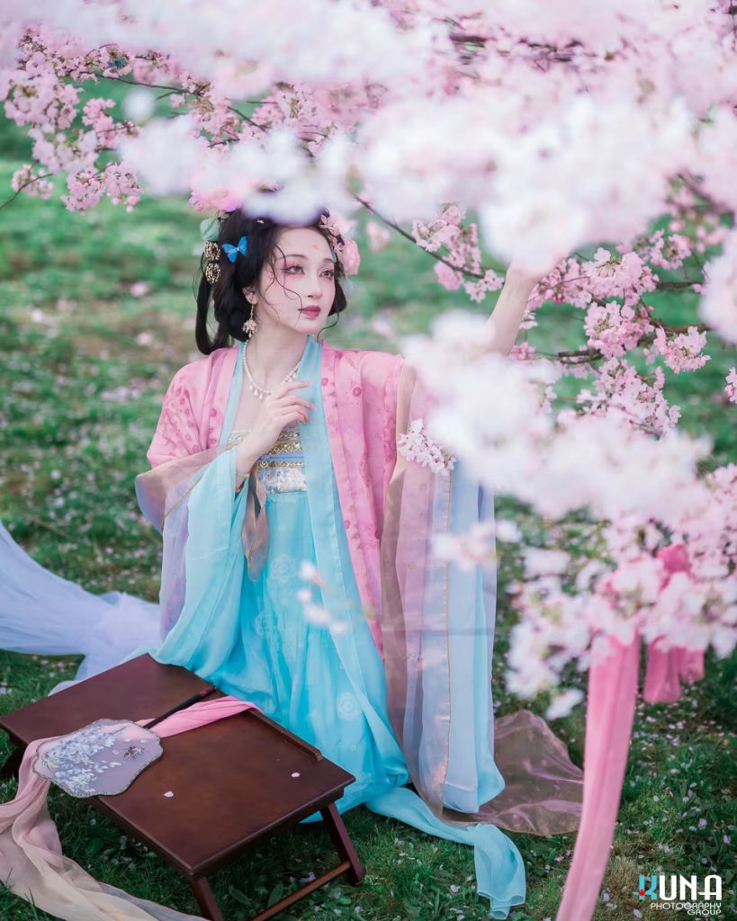 Woman in pink and blue Hanfu standing under cherry blossoms in Vancouver.