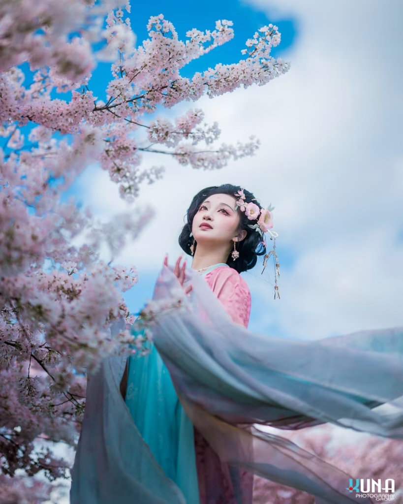 Low angle shot of a Hanfu dress flowing against a blue spring sky.