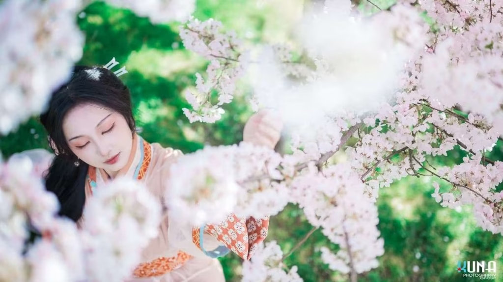 Deep perspective hanfu photography in Richmond BC: Model among a dense cherry blossom tunnel at Larry Berg Flight Path Park 2025.