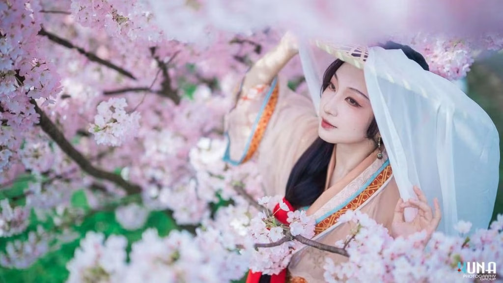 Hanfu portrait with white veil in Metro Vancouver: Subject walking among cherry blossom branches at Larry Berg Flight Path Park 2025.