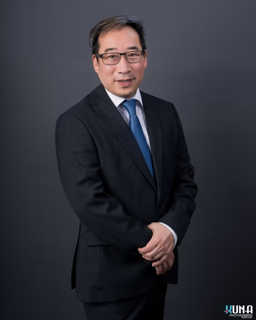Classical corporate board member headshot of a male TCCBC executive with glasses and blue tie in Vancouver British Columbia