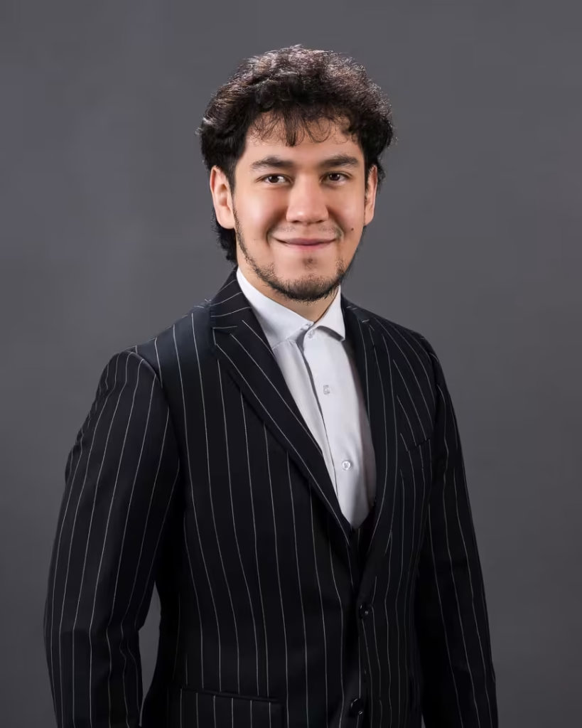 A commercial asset broker at VanHaus wearing a pinstripe suit on a dark charcoal backdrop for a premium vancouver corporate headshot.