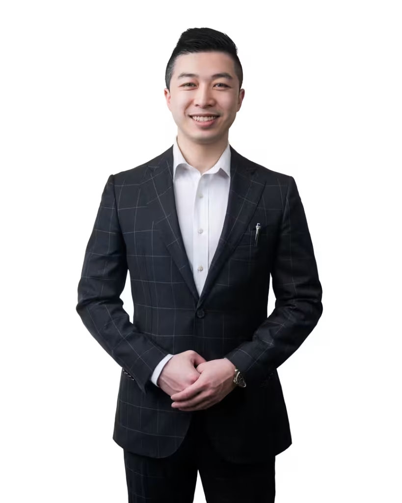 Michael Lee, real estate advisor at VanHaus, posing in a plaid formal suit with hands clasped for his vancouver studio headshot.