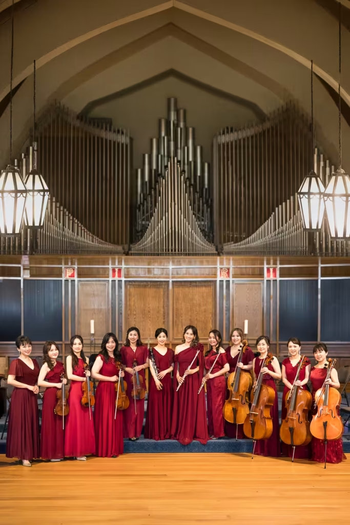 Female musicians of Formosa Music Ensemble posing on stage in front of a giant pipe organ