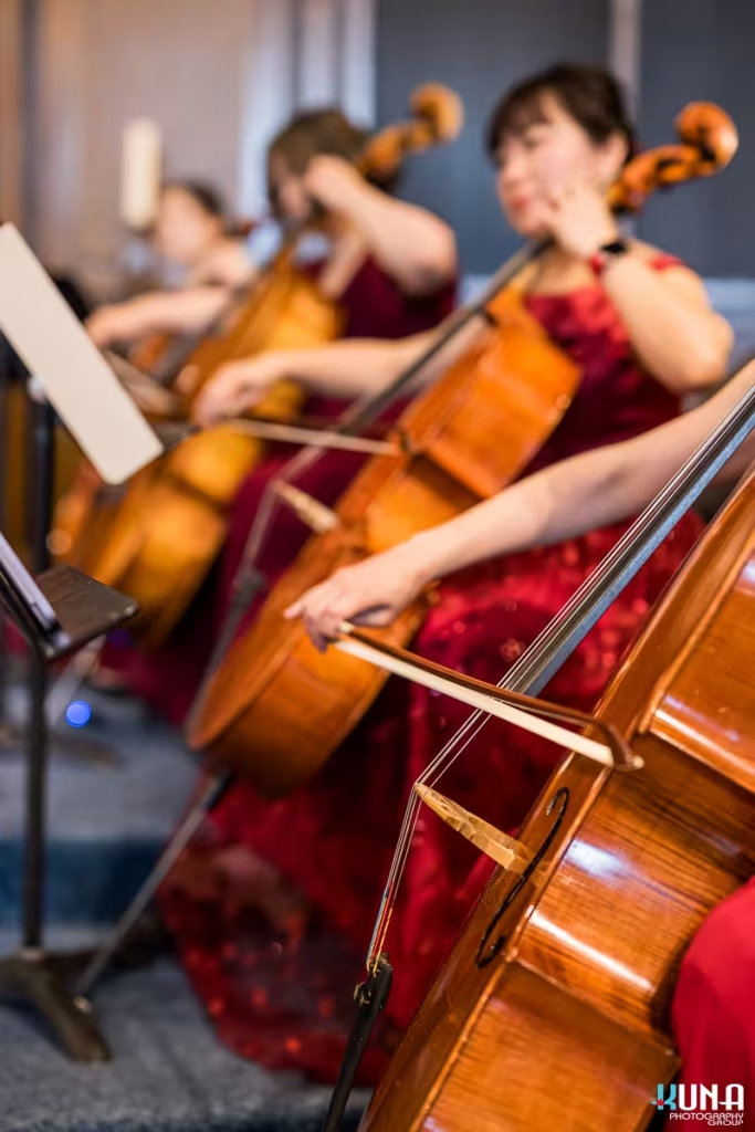 Close up of female cellists in red dresses performing at the Formosa Music Ensemble annual charity concert
