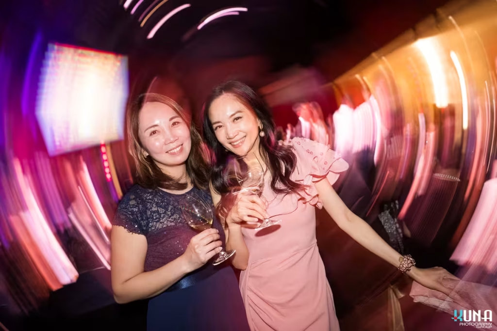 Creative event portrait effects by Vancouver gala photographer Creative radial blur photo of two elegant female guests smiling with wine glasses.