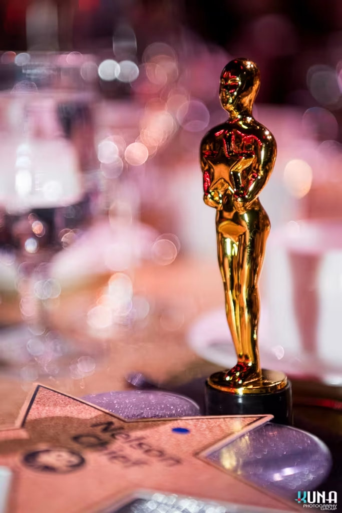 Hollywood theme table decor detail by Vancouver gala photographer Close-up of a golden star trophy center piece on a dinner table with beautiful background bokeh.