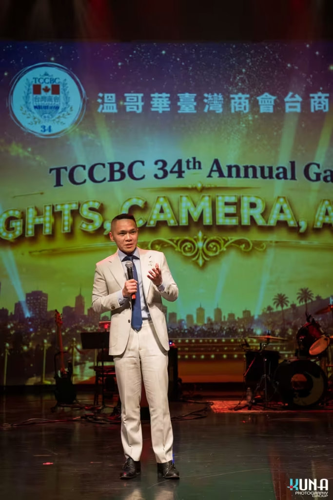 Liberal MP Wade Chang address at TCCBC Gala in Metro Vancouver Liberal MP Wade Chang speaking on stage with the illuminated gala logo behind him.