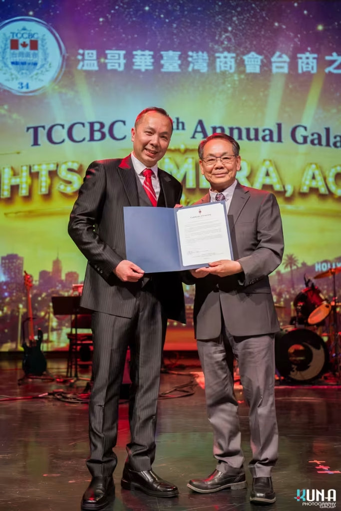 Official certificate presentation ceremony by Vancouver gala photographer President Eddie Chen presenting an official certificate of greeting on stage.