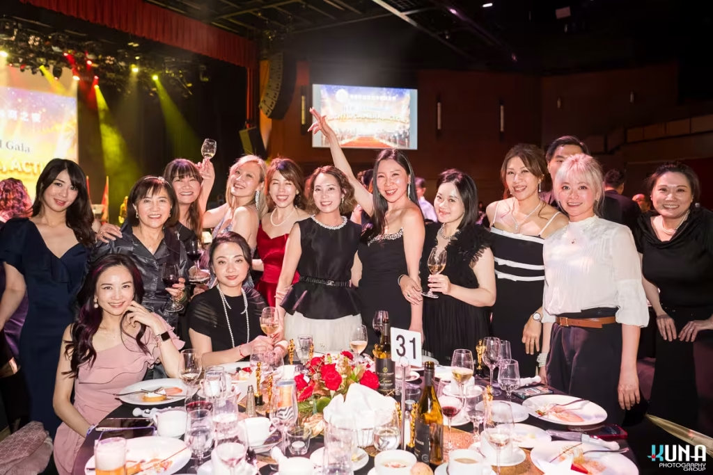 Energetic guest group photo at River Rock Theatre gala dinner A large group of elegantly dressed female attendees cheering from Table 31.