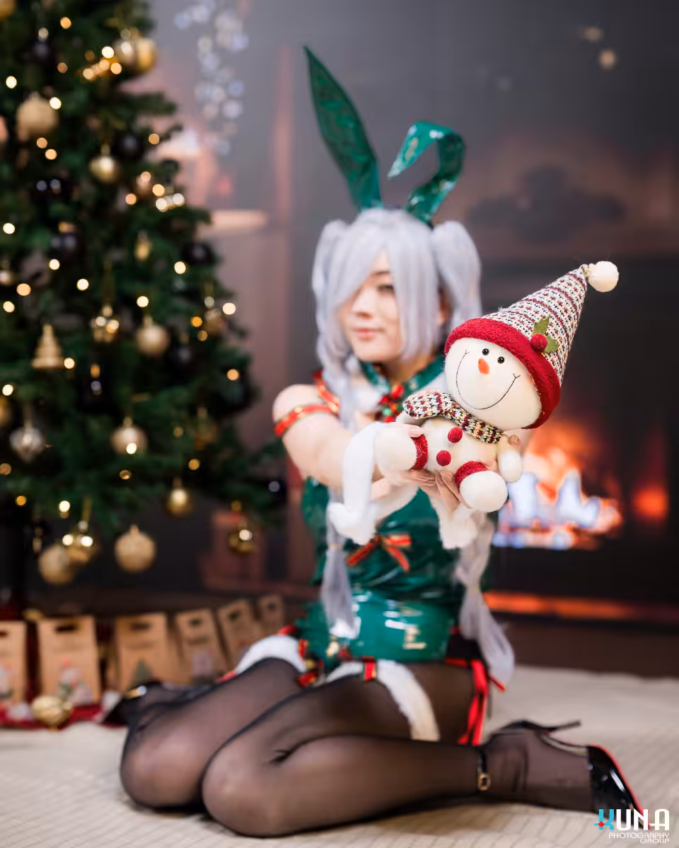 Cosplayer in a festive green bunny outfit holding a cute snowman plush during our Metro Vancouver Christmas mini sessions.